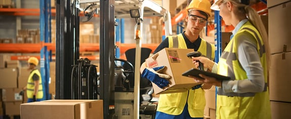 Warehouse employees scanning inventory in 3PL warehouse using management software